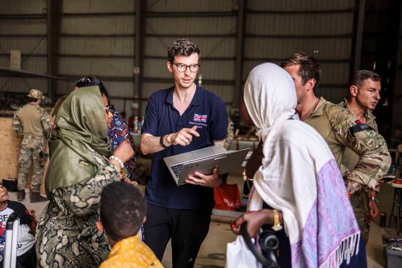 Ein Mitglied des Foreign and Commonwealth Rapid Response Teams hilft Evakuierten, wenn britische Staatsbürger ein RAF-Flugzeug im Sudan besteigen.  Getty Images