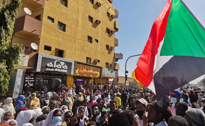 Protesters fly the Sudanese flag as they take to the streets of Khartoum. AFP