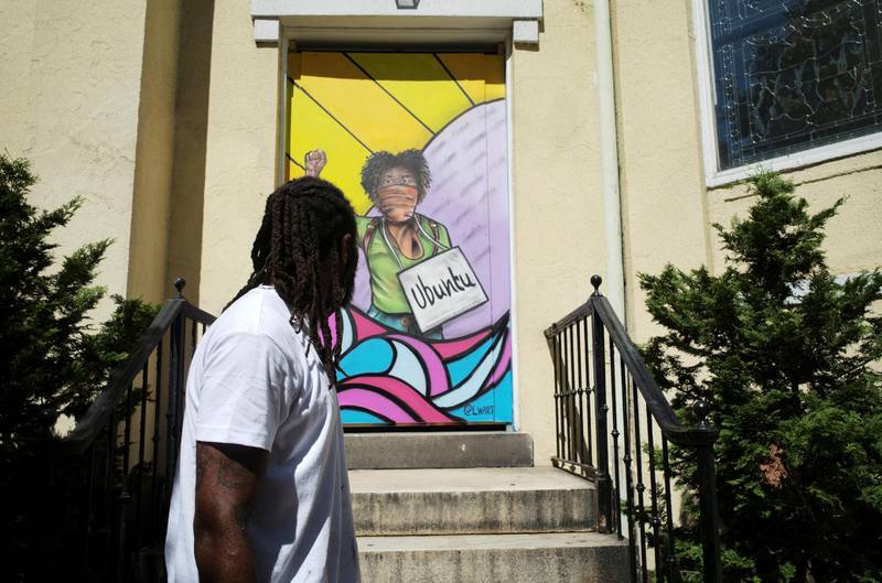 Louie Wri, curated by Paints Institute, looks at his mural on the boarded-up windows of St. John's Church as a work of art activism for racial justice at Black Lives Matter Plaza in Washington, U.S. REUTERS
