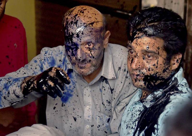 Engineer Rashid, left, a legislator from Jammu and Kashmir state, was doused with ink and engine oil in New Delhi on October 19, 2015, in an attack claimed by the Hindu Sena. Kamal Singh / Press Trust of India via AP