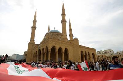 Lebanese demonstrators wave the national flag during a protest against dire economic conditions in downtown Beirut. AFP