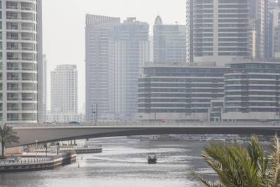 DUBAI, UNITED ARAB EMIRATES. 18 JULY 2020. A boat meanders along the Dubai Marina waterway. Hot and hazy weather in Dubai and the UAE as the fullforce of summer weather hits during the COVID-19 pandemic with residents unable to easily travel due to the preventative measures put in place. (Photo: Antonie Robertson/The National) Journalist: STANDALONE Section: National.