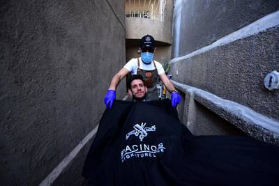 Iraqi itinerant barber Hussain Majid  gives a haircut to a client at his house in Baghdad, Iraq.  EPA