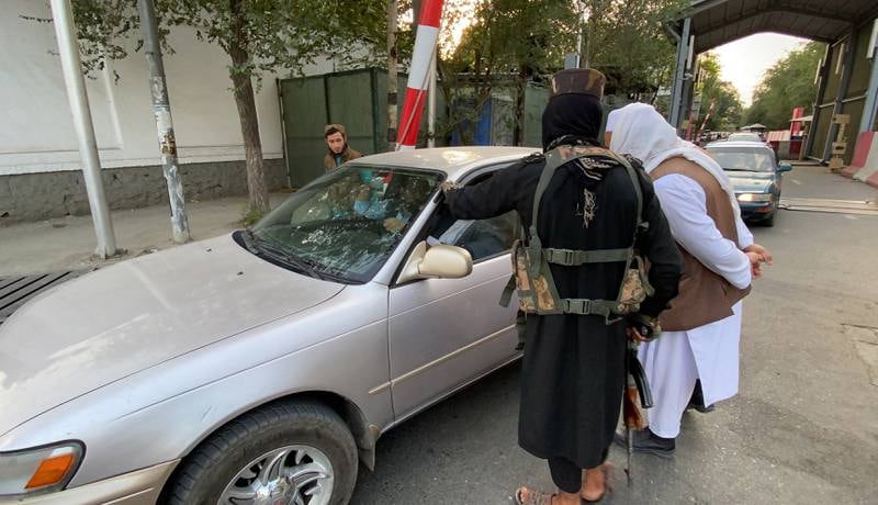 Taliban members check vehicles at the entrance to the Green Zone in Kabul. EPA