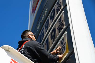 An electrical contractor repairs a sign with petrol prices in Los Angeles, California. AFP