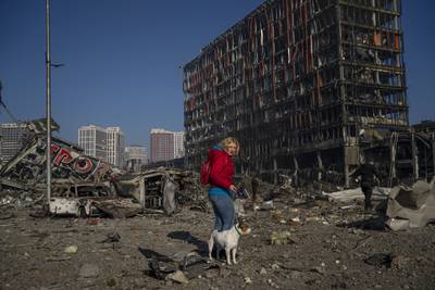 Irina Zubchenko walks her dog Max amid the destruction caused by the shelling of a shopping center in Kyiv. AP