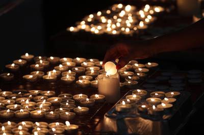 Candles are lit at St Paul's Parish Church in Wokingham, England, for the victims of a multiple fatal stabbing attack, and local teacher James Furlong who was killed Saturday with two other people in Reading town centre, Monday June 22, 2020. PA via AP