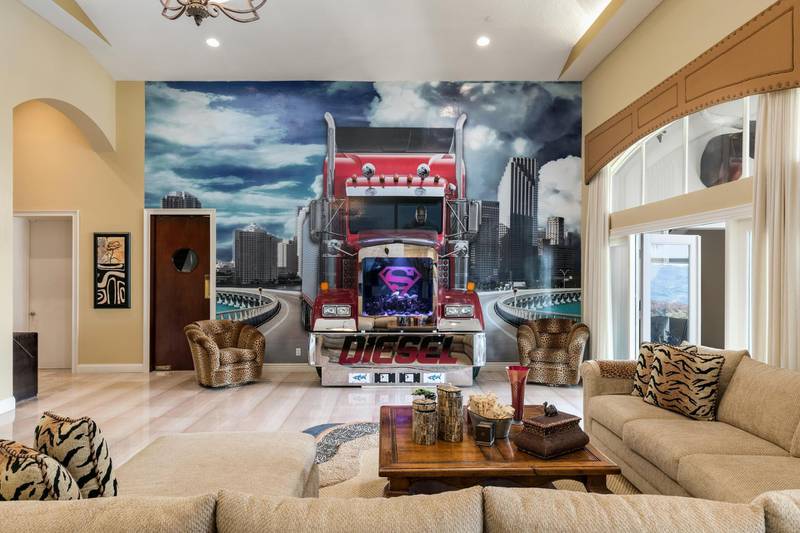 he symbol takes on its most dramatic avatar when embedded into a three-dimensional wall mural, which features a true-to-size tractor trailer barrelling down an expressway, seemingly towards the interior of the living room. The truck’s front cab – with a fish-tank-shaped Superman grille and a gleaming fender with the word Diesel (another of the NBA champion’s nicknames) emblazoned across it – juts out of the wall and into the living space, which is furnished with in-built double sofas. Painted on to the driver’s seat? A serious-looking Shaquille O’Neal himself.
