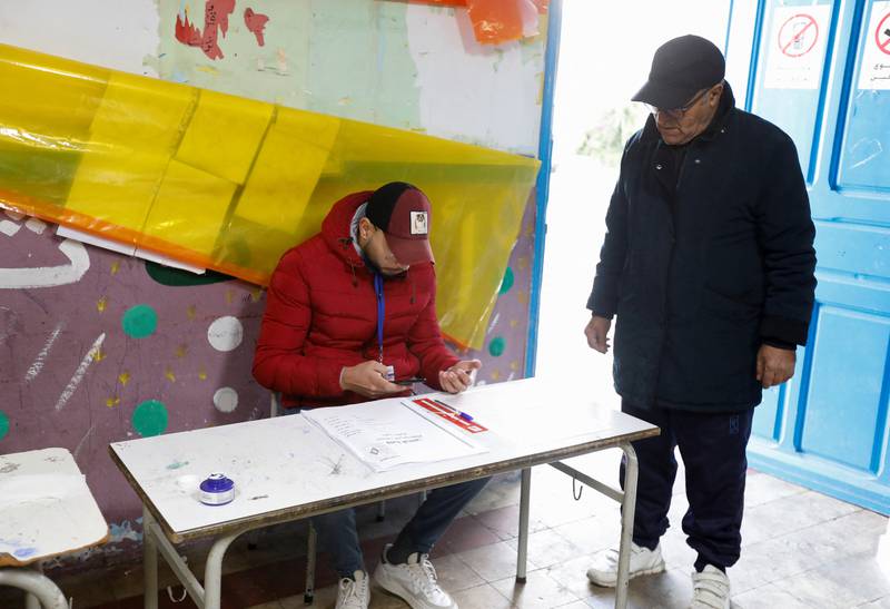 An election worker checks a voter's ID at a polling station. Reuters