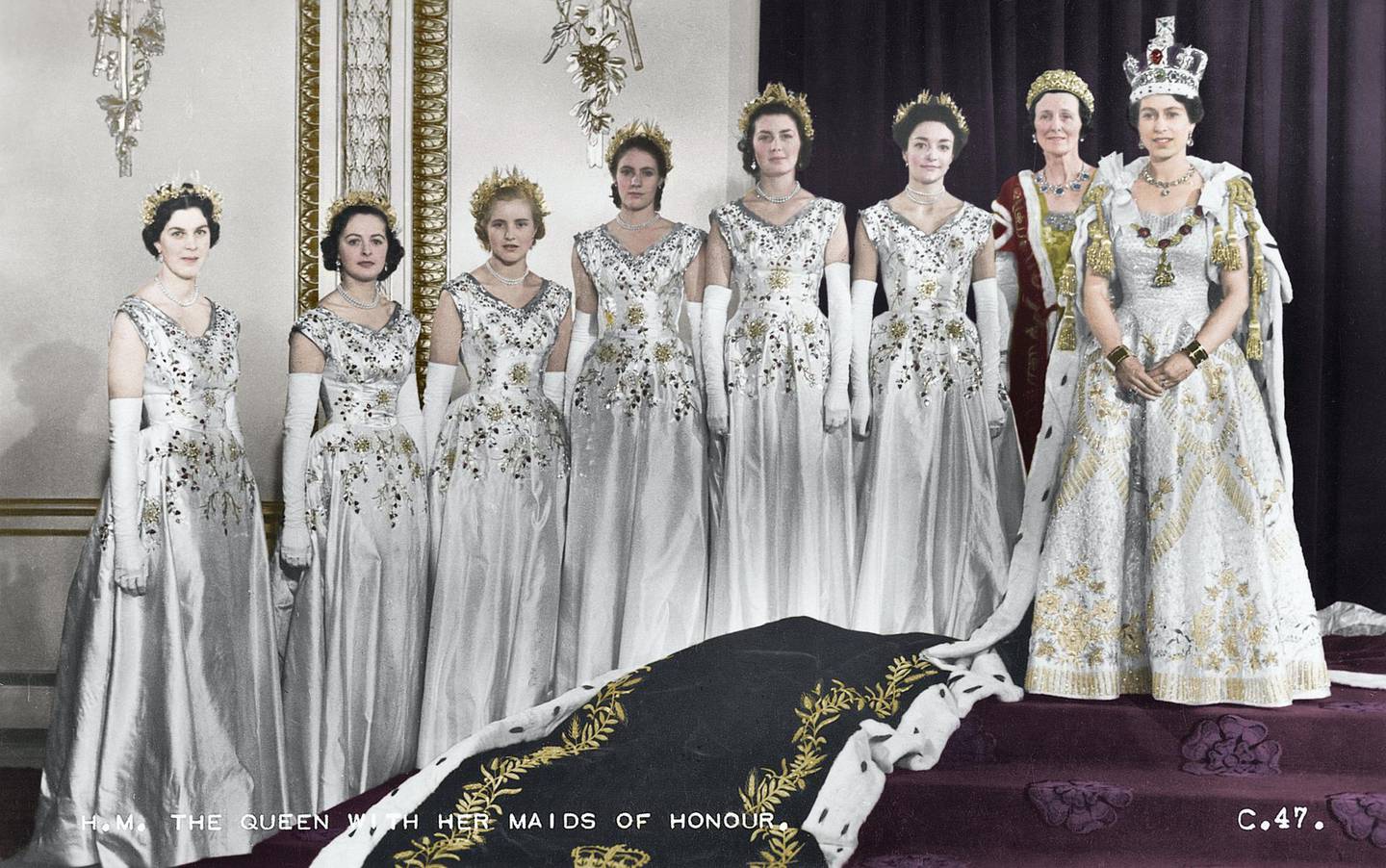 Königin Elizabeth II. mit ihren Ehrendamen, Green Drawing Room, Buckingham Palace, 2. Juni 1953. Mit der Auswahl von sechs Ehrendamen anstelle von Pagen, die ihre Samtschleppe während der Krönungszeremonie tragen, folgte die Königin dem Präzedenzfall von Königin Victoria.  Lady Moyra Hamilton (jetzt Lady Moyra Campbell), Lady Anne Coke (jetzt The Rt Hon The Lady Glenconner), Lady Rosemary Spencer-Churchill (jetzt Lady Rosemary Muir), Lady Mary Baillie-Hamilton (jetzt Lady Mary Russell), Lady Jane Heathcote -Drummond-Willoughby (jetzt The Rt Hon The Baroness Willoughby de Eresby), Lady Jane Vane-Tempest-Stewart (jetzt The Rt Hon The Lady Rayne).  (Kolorierter Schwarz-Weiß-Druck).  Künstler Cecil Beaton.  (Foto von The Print Collector/Getty Images)