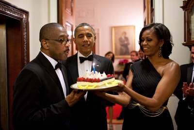 Mr Obama and first lady Michelle Obama present a birthday cake to Assistant Usher Reggie Dickson, June 13, 2012. Photo: The National Archives