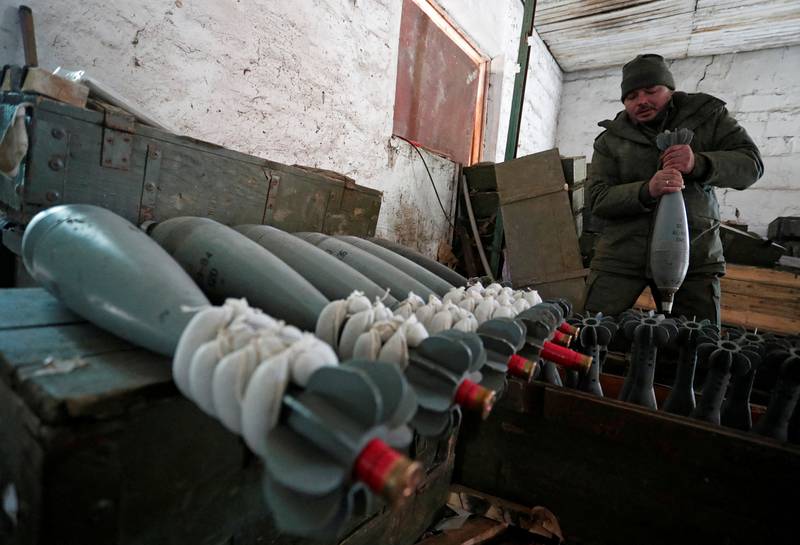 A service member of pro-Russian troops, wearing a uniform without insignia, handles a mortar round at the weapons depot near Marinka, Donetsk. Reuters