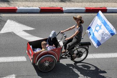 A woman rides with a cart-cycle with children in Tel Aviv. AFP