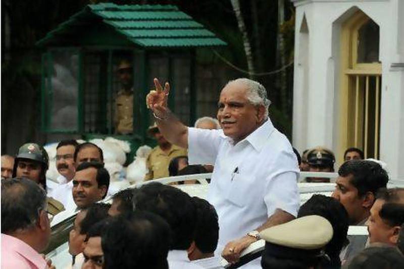 Karnataka's chief minister, BS Yeddyurappa, gestures to the crowd after submitting his resignation in Bangalore. AFP PHOTO/ STR