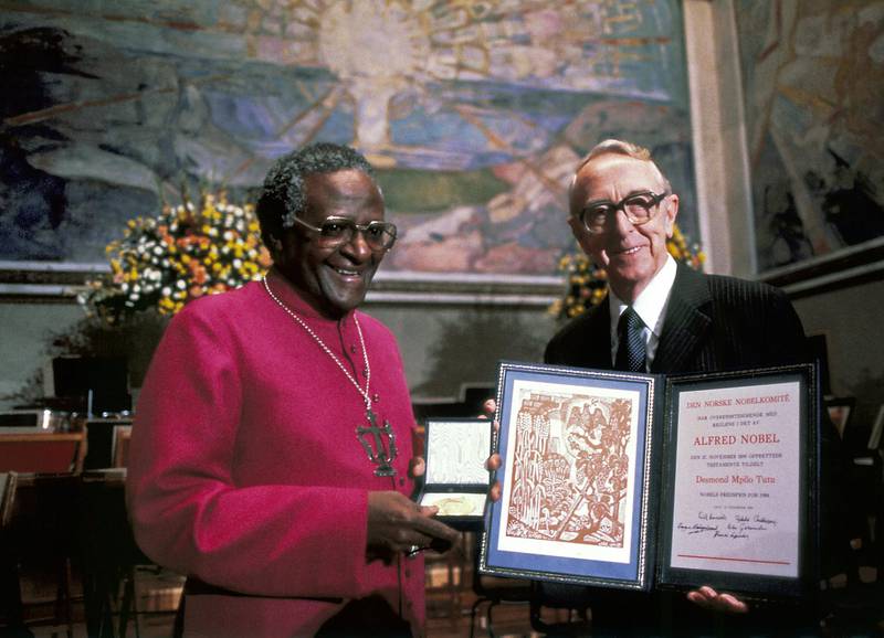 South African Archbishop Mgr Desmond Tutu (L) poses with his Nobel Peace Prize along with Chairman of the Nobel committee Egil Aarvik, 10 December 1984, in Oslo. (Photo by - / AFP)
