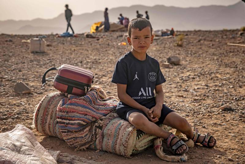 An Amazigh boy and his belongings in the Moroccan desert.