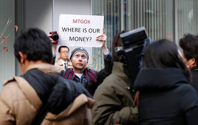 Kolin Burges, a self-styled cryptocurrency trader and former software engineer from London, holds up a placard to protest against Mt. Gox, in front of the building where the digital marketplace operator was formerly housed in Tokyo February 26, 2014. Japanese authorities are looking into the abrupt closure of Mt. Gox, the top government spokesman said on Wednesday in Tokyo's first official reaction to the turmoil at what was the world's biggest exchange for bitcoin virtual currency.    REUTERS/Toru Hanai (JAPAN - Tags: BUSINESS SCIENCE TECHNOLOGY CIVIL UNREST) - GM1EA2Q181I01