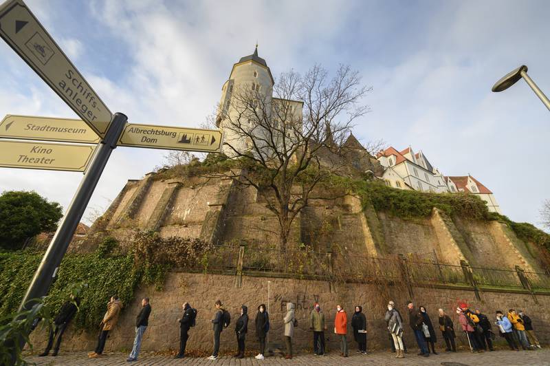 People wait to be vaccinated below Albrechtsburg castle and the cathedral in Meissen, Germany. AP