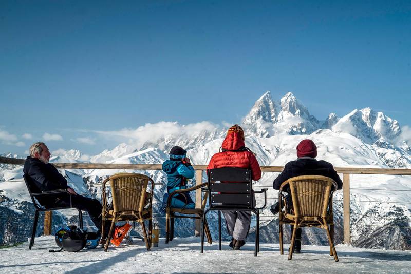 TOPSHOT - A picture taken on January 28, 2018 shows people as they relax at the Hatsvali ski-resort. 
With its rugged landscape of rocky peaks, virgin slopes and breathtaking vistas, Georgia's most isolated region, Upper Svaneti, is a magnet for skiers and even hopes to host the Winter Olympics one day. Famous for its ancient villages dotted with stone watchtowers, forested gorges and alpine valleys, this tiny Caucasus region is one of the highest and most remote settlements in Europe.
 / AFP PHOTO / Andrey BORODULIN / TO GO WITH AFP STORY by Andrey BORODULIN