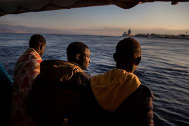 Men who were rescued off the Libyan coast on Friday, watch the city of Messina from the deck of the Open Arms rescue vessel. AP 