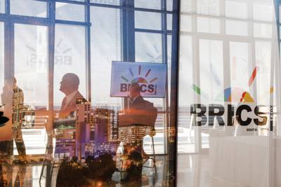 Delegates walk past logos of the Brics summit at the Sandton Convention Centre in Johannesburg on August 23. Pool/ AFP