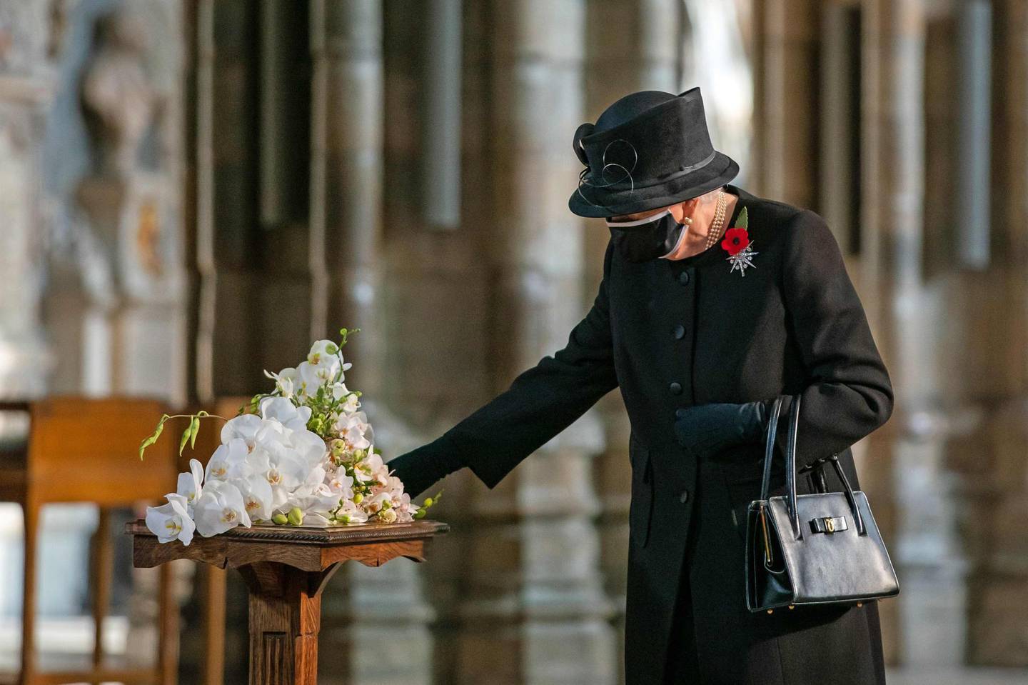 Britain's Queen Elizabeth II touches a bouquet of flowers to be layed at the grave of the Unknown Warrior to mark the centenary of the burial of the Unknown Warrior ahead of Remembrance Sunday at Westminster Abbey in London on November 4, 2020.  In the small private ceremony, The Queen honoured the Unknown Warrior and the Royal Family’s own associations with the First World War and the grave at Westminster Abbey.
As part of the ceremony, a bouquet of flowers featuring orchids and myrtle - based on Her Majesty’s own wedding bouquet from 1947 - was placed on the grave of the Unknown Warrior in an act of remembrance. The gesture reflected the custom of Royal bridal bouquets being placed on the grave, a tradition which began in 1923 when Lady Elizabeth Bowes-Lyon, the future Queen Elizabeth The Queen Mother, laid her bouquet as she entered the Abbey in memory of her brother Fergus, who was killed at the Battle of Loos in 1915.
The grave of the Unknown Warrior is the final resting place of an unidentified British serviceman who died on the battlefields during the First World War. The serviceman’s body was brought from Northern France and buried at Westminster Abbey on 11th November 1920 after a procession through Whitehall.  / AFP / POOL / PA WIRE / Aaron Chown
