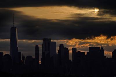 The sun is partially eclipsed as it rises over lower Manhattan in New York. AP Photo