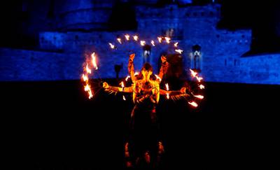 Members of PyroCeltica pose in front of Edinburgh Castle in advance of Edinburgh's Hogmanay torchlit procession. Reuters