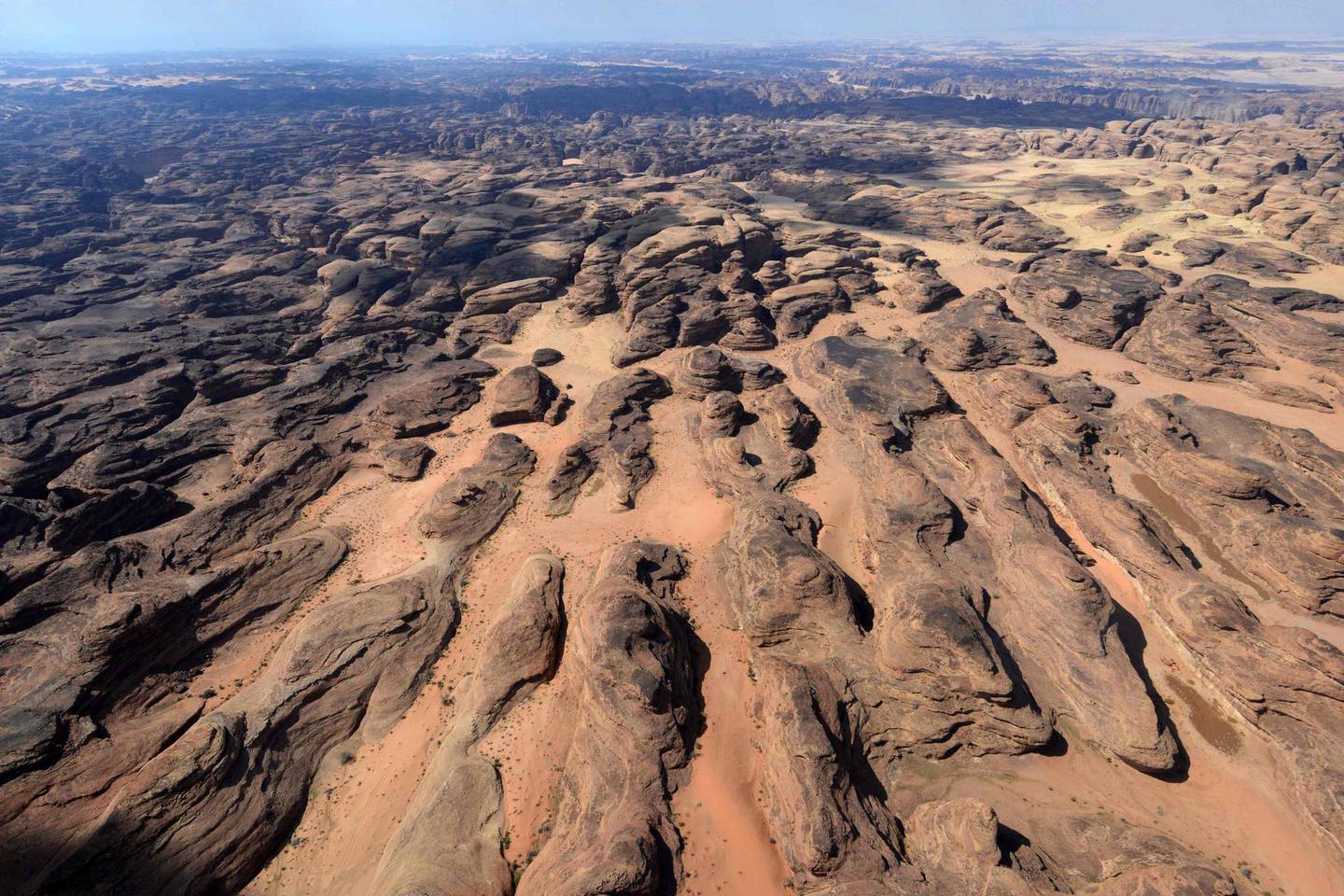 (FILES) This file photo taken on February 11, 2019 shows an aerial view of the coloured rocks in the Ula desert near the northwestern Saudi town of al-Ula. Citizens from 49 countries are now eligible for tourist visas online or on arrival to Saudi Arabia, thanks to a landmark decision enacted last month, relaxing rules that had largely restricted visits to business travellers and Muslim pilgrims, with the authorities banking on large cities like the capital Riyadh and the western Red Sea port of Jeddah through large-scale investments, including in entertainment.
 / AFP / FAYEZ NURELDINE
