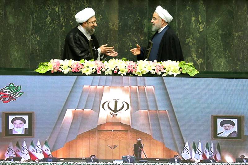 Iranian president Hassan Rouhani extends his hand to Iran's Judiciary Chief Sadegh Larijani during a swearing-in ceremony for Rouhani for a further term, at the parliament in Tehran, Iran, August 5, 2017. Nazanin Tabatabaee Yazdi/TIMA via REUTERS ATTENTION EDITORS - THIS IMAGE WAS PROVIDED BY A THIRD PARTY.     TPX IMAGES OF THE DAY