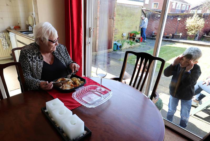Zac looks through the window at Vera Barnett after delivering a carvary from the Sneyd Arms on Mother's Day in Keele, Newcastle-under-Lyme, Britain. Reuters