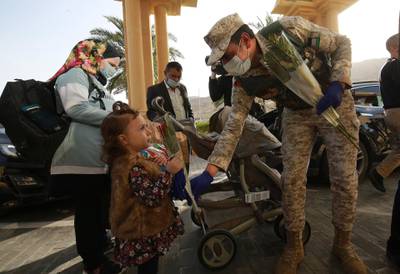Jordanian soldiers hand flowers to people amongst the first group of people who were on a two-week quarantine in resorts and hotels at the Dead Sea, 60km south of Amman.  EPA