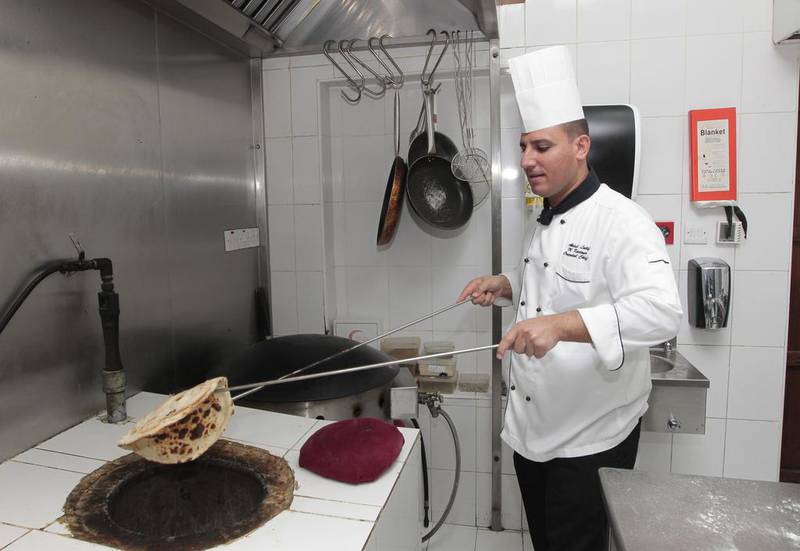 Abdulatif Ghandoor, oriental chef at Arabian Courtyard, cooking traditional Emirati bread at the Barjeel Guest House. Jeffrey E Biteng / The National 