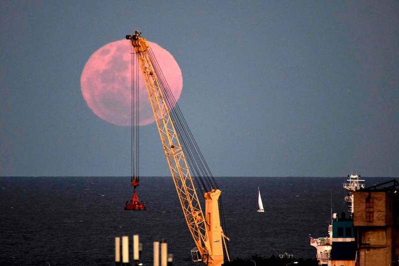 The "blue moon", the second full moon of a calendar month, is seen over the La Plata River, near a crane, in Buenos Aires, Argentina. AFP