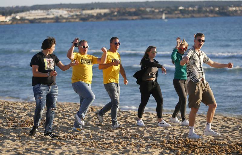 Tourists from Germany dance on El Arenal beach in Palma de Mallorca, Spain, following Berlin's lifting of quarantine requirements for travellers returning from the Balearic Islands. Reuters