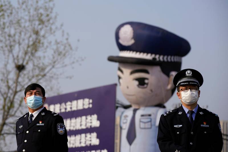 Police officers stand guard near an inflatable depicting a police officer at a toll station of an expressway after travel restrictions to leave Wuhan were lifted. Reuters