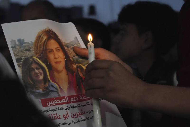 A Palestinian holds a candle and a picture of Abu Akleh in front of the Al Jazeera offices in Gaza city. AP Photo
