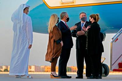 US Secretary of State Mike Pompeo (2nd-R) and his wife Susan (R) speak with US Ambassador to the United Arab Emirates John Rakolta and his wife Terry after stepping off a plane at al-Bateen Executive Airport in Abu Dhabi on November 20, 2020.  / AFP / POOL / Patrick Semansky
