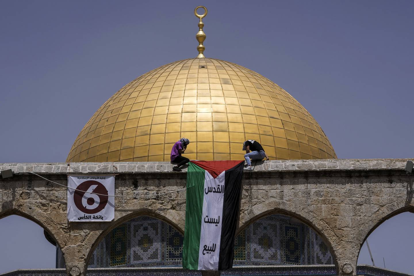 Masked Palestinians hang the national flag during Ramadan in front of the Dome of the Rock shrine at the Al Aqsa Mosque compound in Jerusalem's Old City in April. AP Photo