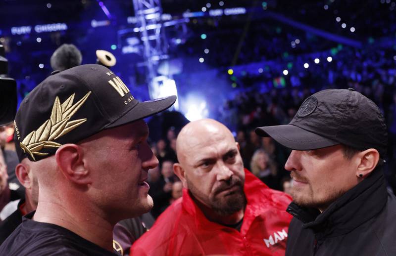 Tyson Fury and Oleksandr Usyk square off in the ring after Fury retained his WBC heavyweight world title with a 10th-round TKO win over Derek Chisora at the Tottenham Hotspur Stadium in London on December 3, 2022. Reuters