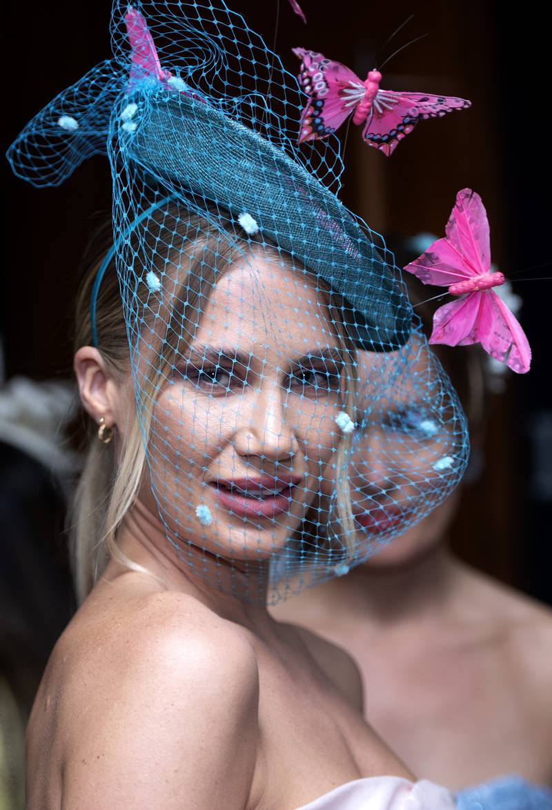Butterflies sit atop the netting of this green-blue fascinator. AP Photo