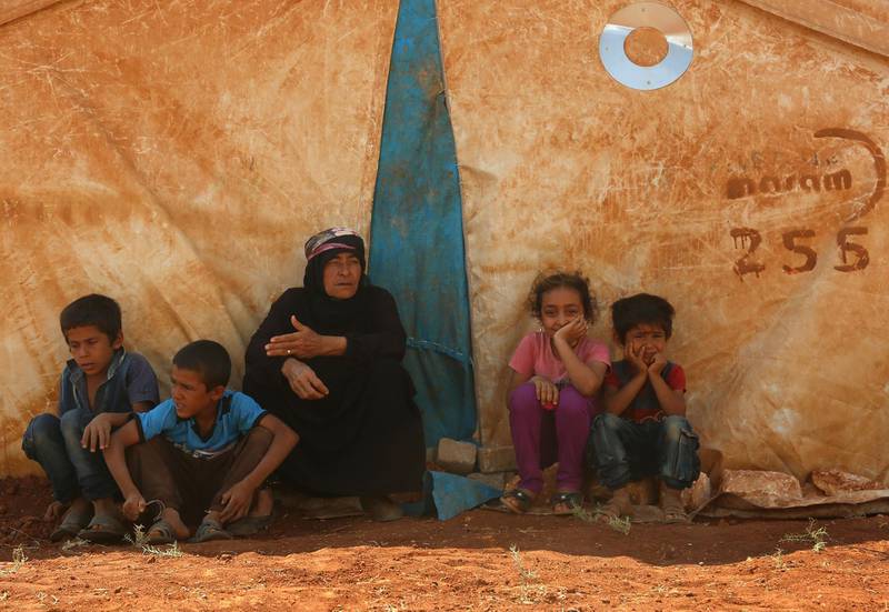 Displaced Syrians rest by a tent at a camp in Kafr Lusin near the border with Turkey in the northern part of Syria's rebel-held Idlib province on September 9, 2018. - Regime and Russian air raids pounded Syria's last major rebel bastion of Idlib today after an overnight lull, killing at least one child, a monitor said. (Photo by Zein Al RIFAI / AFP)