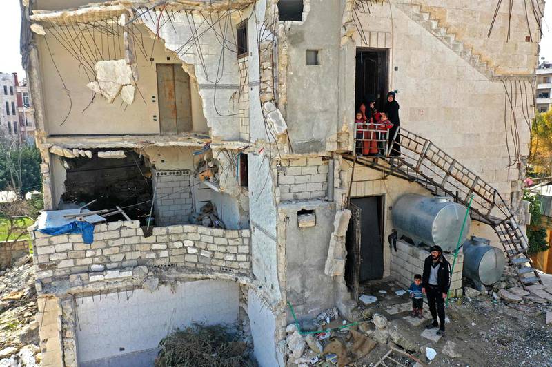A displaced family from Abu Al Duhur in eastern Idlib have taken shelter in a building damaged in air strikes by the Syrian regime. AFP