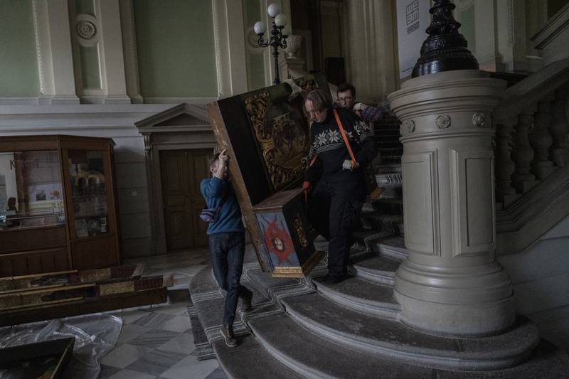 Workers move a Baroque sacred art piece.