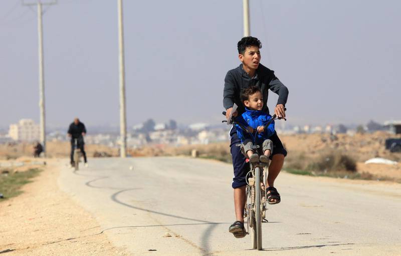 Syrian refugees ride their bicycles in the Zaatari camp, where a Covid-19 vaccination programme has begun. EPA