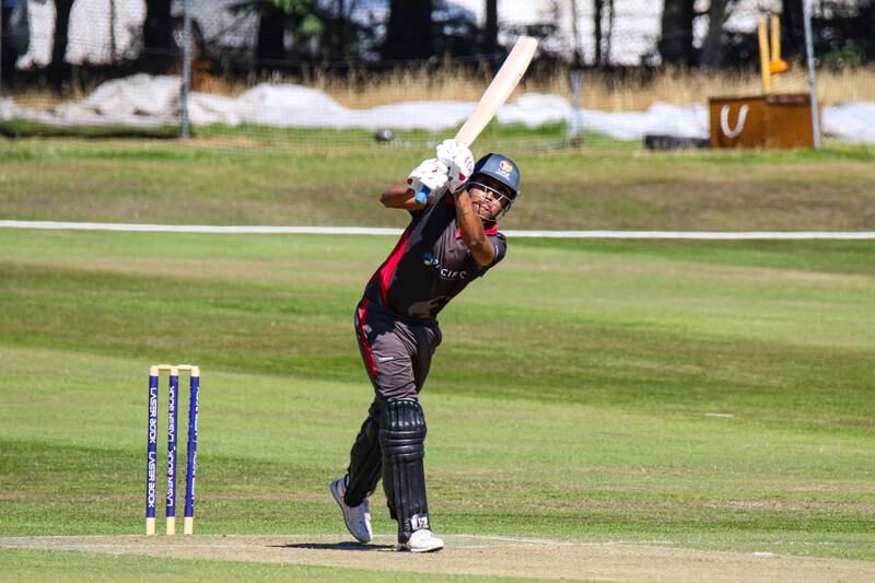 UAE batter Aryan Lakra drives over mid-on for a boundary. 