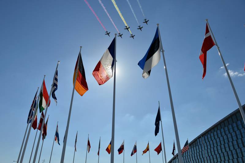 Fighter jets fly over flags at Nato headquarters in Brussels, Belgium. Getty