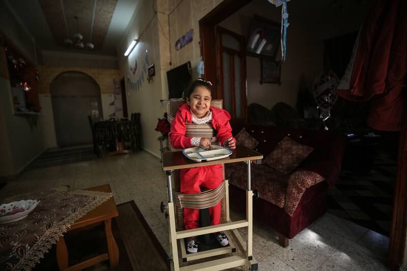 Palestinian girl Sara Al Metrabei, 5, stands with the aid of a medical device. All photos: Majd Mahmod / The National