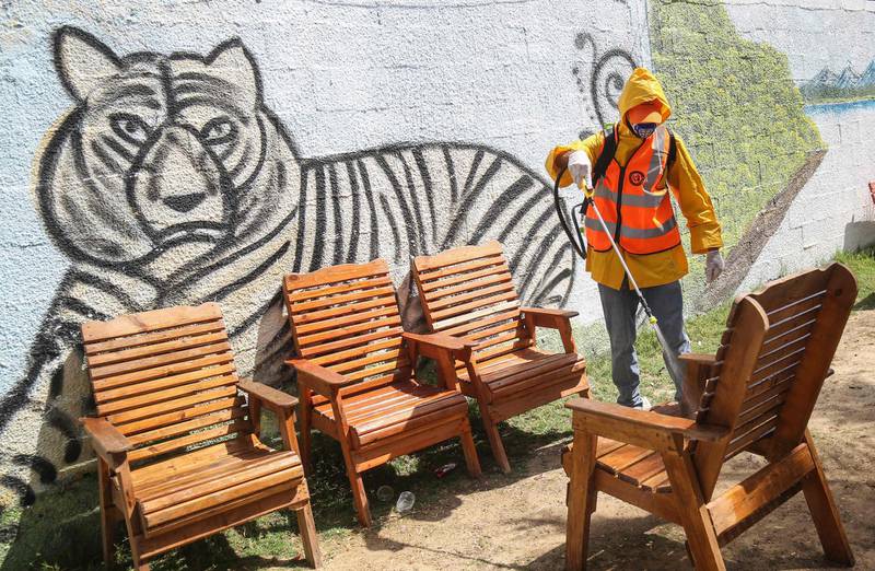 A Palestinian municipality worker disinfects the chairs at Rafah Zoo in the southern Gaza Strip.  AFP