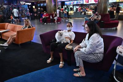 Dog owners and their pets wait in the wait in the cinema lobby. AFP
